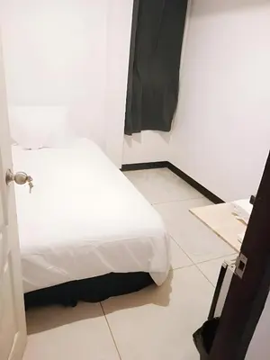 a bedroom with a white bed and a tiled floor at XX GO INN Asiatique Bangkok - โกอินน์ เอเชียทีค เจริญกรุง in Bangkok
