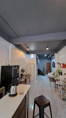 a kitchen and living room with a table and chairs at Casita Hostel House Bangkok in Bangkok