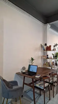 a laptop computer sitting on a wooden table in a room at Casita Hostel House Bangkok in Bangkok