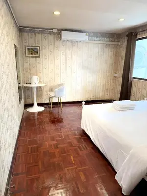 a bedroom with a bed and a table and a chair at XX Stay On Sukhumvit Soi 11 BTS Nana Pro in Makkasan
