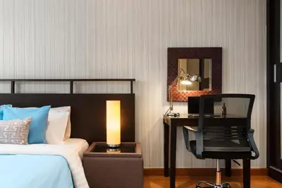 a bedroom with a bed and a desk and a chair at Azure Dreams King Suite Retreat near BTS & Fast WiFi in Khlong Toei