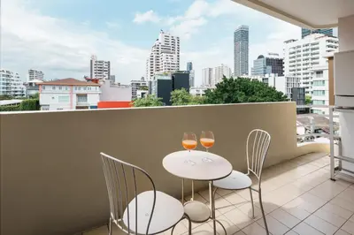 two glasses of wine on a balcony with a city skyline at Azure Dreams King Suite Retreat near BTS & Fast WiFi in Khlong Toei