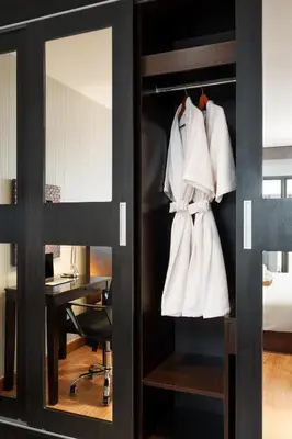 a closet with white robes and a desk in a room at Azure Dreams King Suite Retreat near BTS & Fast WiFi in Khlong Toei