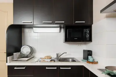 a kitchen with a sink and a microwave at Azure Dreams King Suite Retreat near BTS & Fast WiFi in Khlong Toei