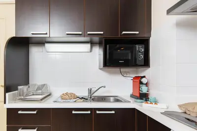 a kitchen with a sink and a microwave at Verdant Vista King Suite near BTS with Modern Amenities in Khlong Toei