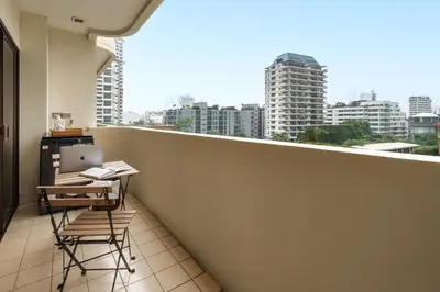 a balcony with a table and chairs and a laptop at Verdant Vista King Suite near BTS with Modern Amenities in Khlong Toei