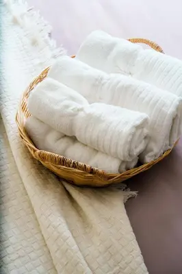 a basket filled with white towels on a table at Mystic Haven King Bed Suite with Balcony & City Views in Khlong Toei