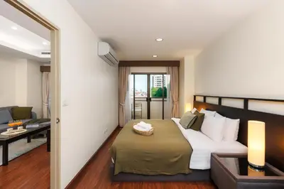 a bedroom with a bed and a living room at Jungle Dream King Bed Oasis with Balcony & High-Speed WiFi in Khlong Toei