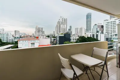 a balcony with chairs and a view of the city at Jungle Dream King Bed Oasis with Balcony & High-Speed WiFi in Khlong Toei
