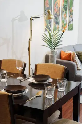 a dining room table with plates and glasses on it at Jungle Dream King Bed Oasis with Balcony & High-Speed WiFi in Khlong Toei