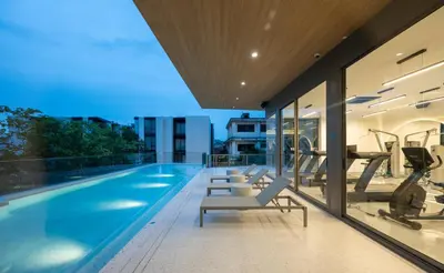 an indoor swimming pool with fitness equipment on a building at The Moment in Bangkok