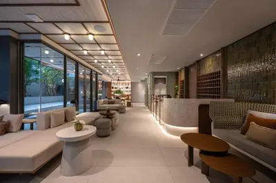 a lobby of a building with couches and a bar at The Moment in Bangkok