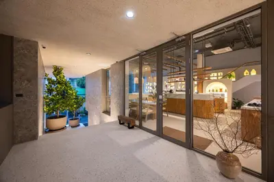 a building with large glass windows and a patio at The Moment in Bangkok