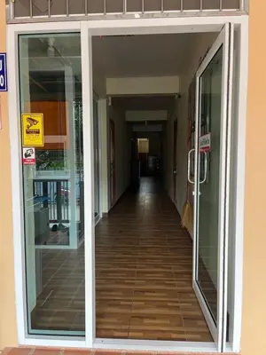 an empty hallway of a building with glass doors at Boontorsub in Ban Khlong Samrong
