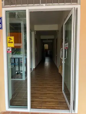 an empty hallway in a building with glass doors at Boontorsub in Ban Khlong Samrong