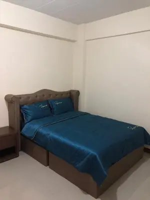 a bedroom with a bed with blue sheets and blue pillows at Boontorsub in Ban Khlong Samrong