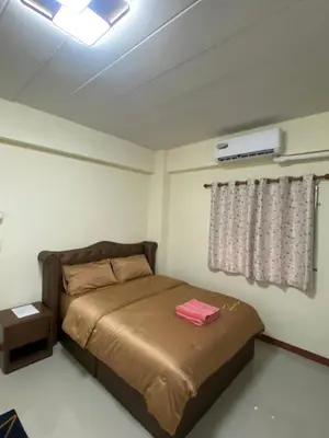 a bedroom with a bed and a air conditioner at Boontorsub in Ban Khlong Samrong