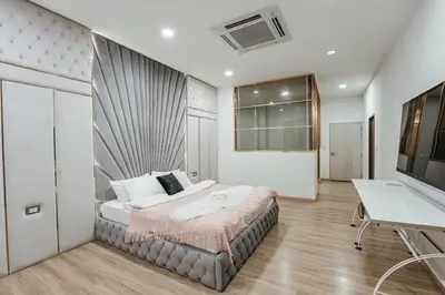 a bedroom with a bed and a desk and a television at Nordic Villa 5BR Pool, Jacuzzi, Rooftop and More in Ban Bang Krang