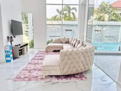 a living room with a large couch and a table at Nordic Villa 5BR Pool, Jacuzzi, Rooftop and More in Ban Bang Krang