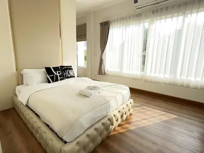 a bedroom with a large bed with a large window at Nordic Villa 5BR Pool, Jacuzzi, Rooftop and More in Ban Bang Krang
