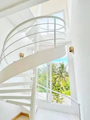 a spiral staircase in a house with a window at Nordic Villa 5BR Pool, Jacuzzi, Rooftop and More in Ban Bang Krang