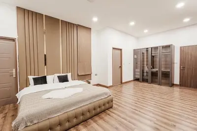 a large bedroom with a large bed and wooden floors at Nordic Villa 5BR Pool, Jacuzzi, Rooftop and More in Ban Bang Krang