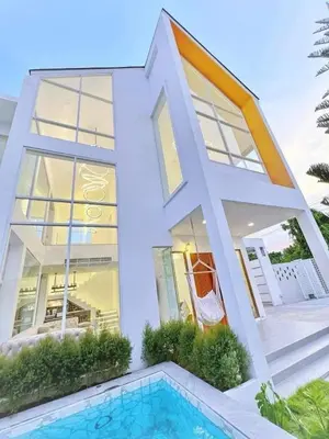 a house with a swimming pool in front of it at Nordic Villa 5BR Pool, Jacuzzi, Rooftop and More in Ban Bang Krang