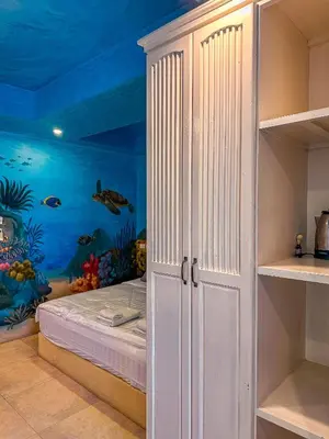 a bedroom with an under the ocean mural at Thongtara House Boutique Srinakarin in Bangkok