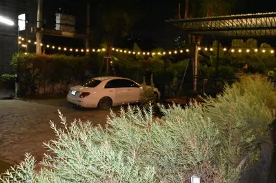 a white car parked in a parking lot at night at Thongtara House Boutique Srinakarin in Bangkok
