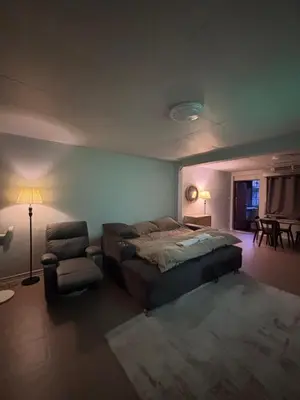 a bedroom with a bed and a chair and a lamp at Mango Hostel - 420 Friendly in Bangkok