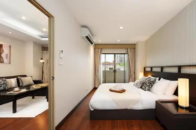 a bedroom with a bed and a desk and a couch at King-Suite with Balcony and a full Kitchen near ThonglorBTS in Khlong Toei