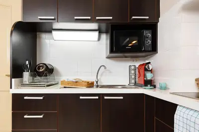 a kitchen with a sink and a microwave at King-Suite with Balcony and a full Kitchen near ThonglorBTS in Khlong Toei