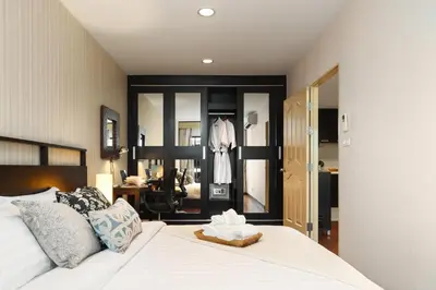 a bedroom with a bed and a desk in a room at King-Suite with Balcony and a full Kitchen near ThonglorBTS in Khlong Toei