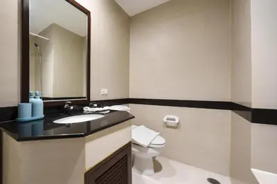 a bathroom with a sink and a toilet and a mirror at King-Suite with Balcony and a full Kitchen near ThonglorBTS in Khlong Toei