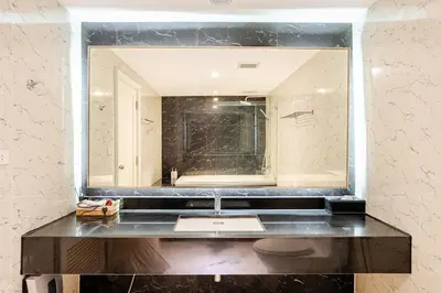 a bathroom with a sink and a large mirror at State tower City view Central River Station in Bangkok
