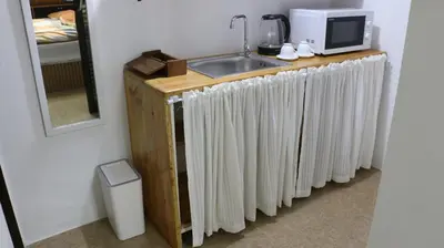 a kitchen counter with a sink and a microwave at Nich Houses Craft&More in Sathani Sala Ya