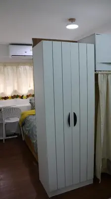 a white cabinet in a bedroom with a bed at Nich Houses Craft&More in Sathani Sala Ya