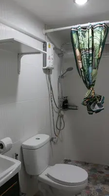 a bathroom with a toilet and a shower curtain at Nich Houses Craft&More in Sathani Sala Ya
