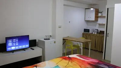 a room with a bed and a flat screen tv at Nich Houses Craft&More in Sathani Sala Ya