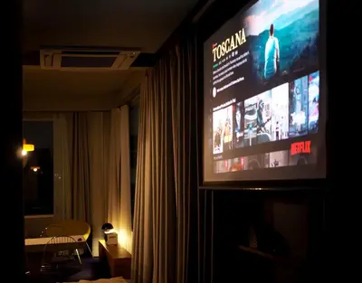 a television in a dark room with a room with at Citrus House Phra-Arthit in Bangkok