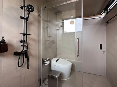 a bathroom with a toilet and a glass shower at Citrus House Phra-Arthit in Bangkok