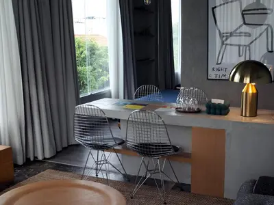 a room with a desk with three chairs and a window at Citrus House Phra-Arthit in Bangkok