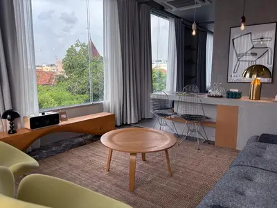 a living room with a table and chairs and a kitchen at Citrus House Phra-Arthit in Bangkok
