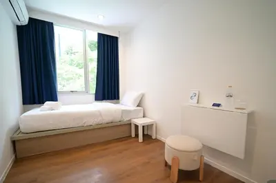 a bedroom with a bed and a window at Yummy House in Bangkok