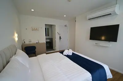 a bedroom with a large bed and a flat screen tv at Yummy House in Bangkok
