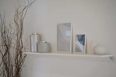a white shelf with two pictures and a mirror at Yummy House in Bangkok