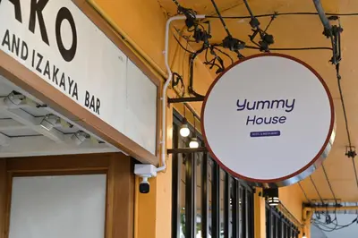 a sign for a jimmy house on the side of a store at Yummy House in Bangkok