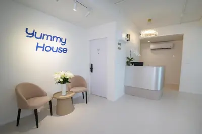a waiting room with two chairs and a table with flowers at Yummy House in Bangkok