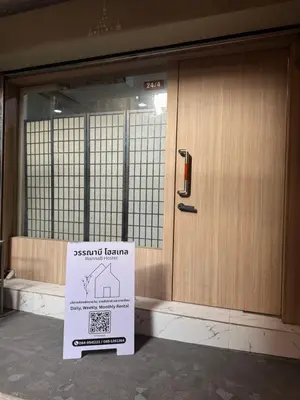 a sign is sitting in front of a door at WannaB Hostel in Khlong San