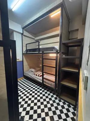 two bunk beds in a room with a checkered floor at WannaB Hostel in Khlong San